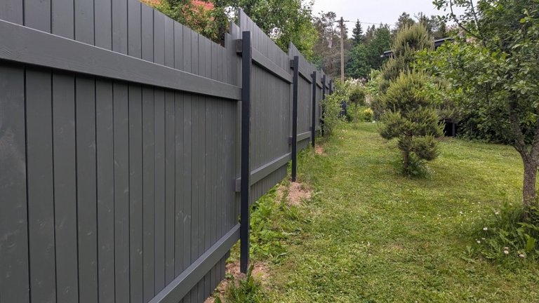 Anthracite wooden fence along a lawn