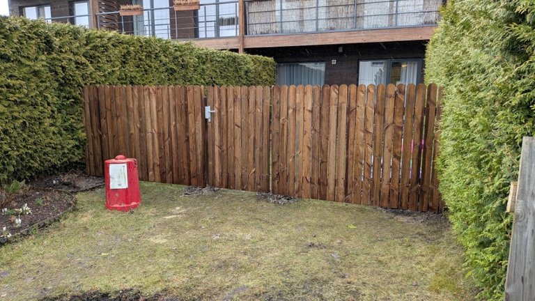Small impregnated wooden picket fence with a gate