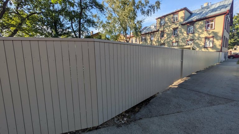 Light wooden picket fence for an apartment association, with a gate and walkway