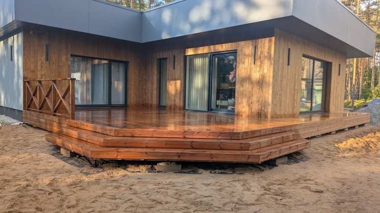 Heat-oiled timber terrace with corner steps and glass door