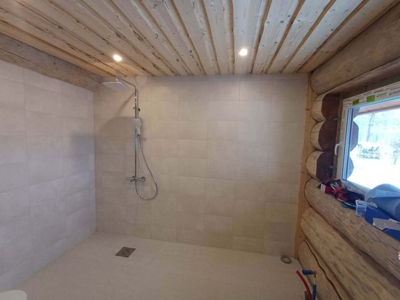 Modern shower and tiling in a log-house bathroom